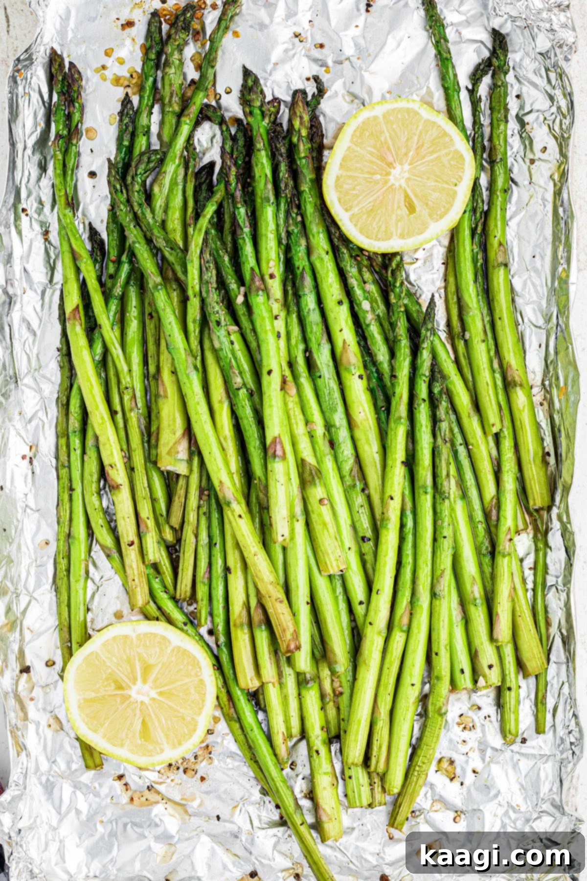A vibrant, close-up overhead view of perfectly cooked smoked asparagus spears, seasoned with fresh lemon and minced garlic, arranged artfully on a serving dish.