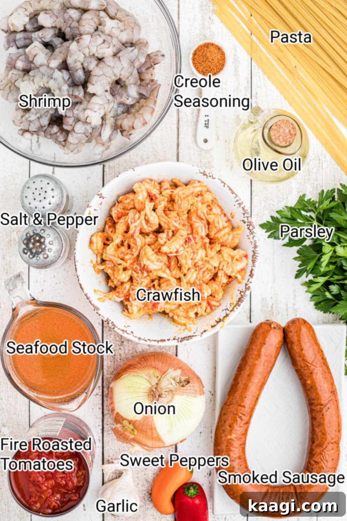 A vibrant display of fresh ingredients laid out, including shrimp, crawfish tails, vegetables, and seasonings, ready for making crawfish pastalaya.
