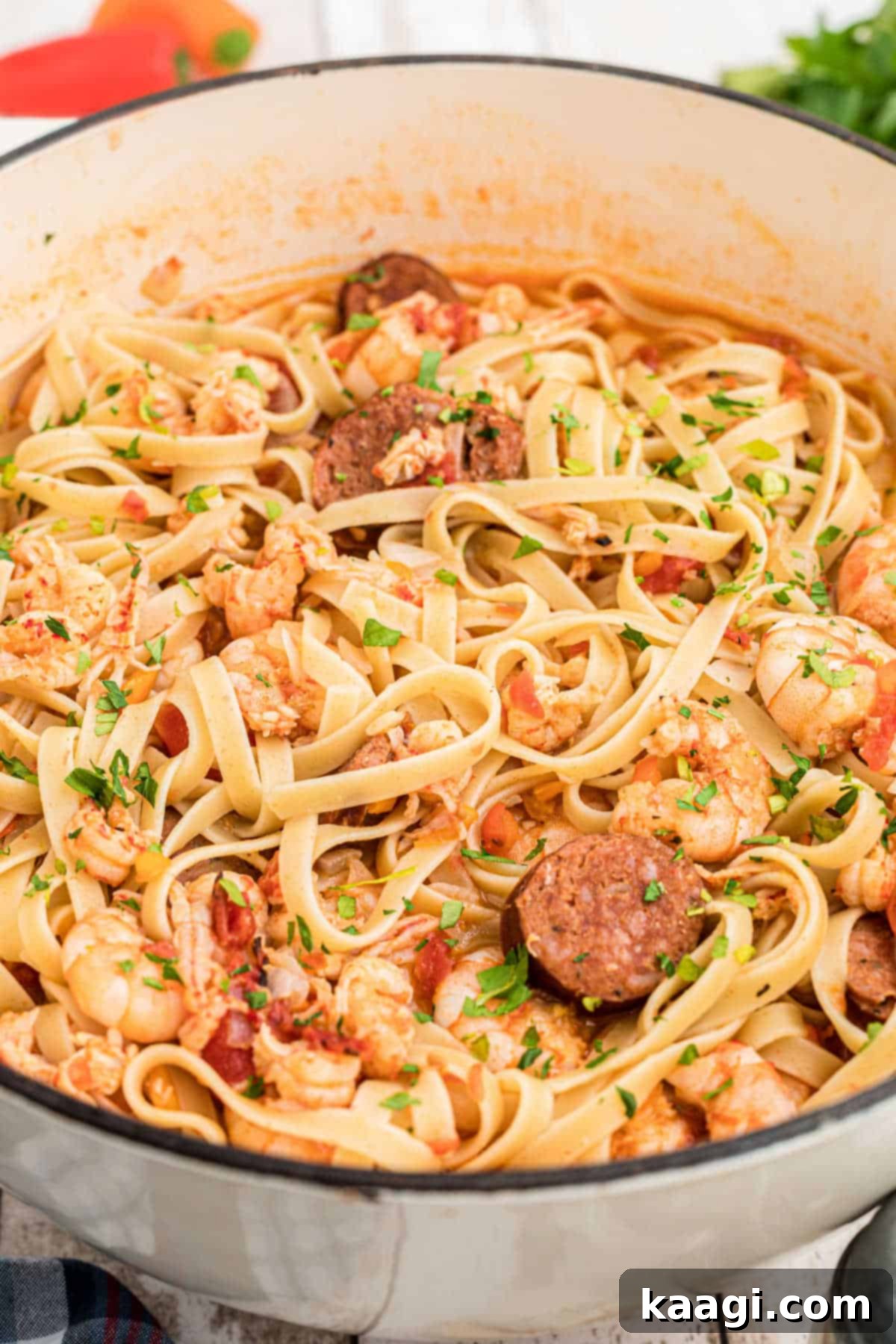 A large Dutch oven filled to the brim with a steaming, rich crawfish and shrimp pastalaya, ready to be served.