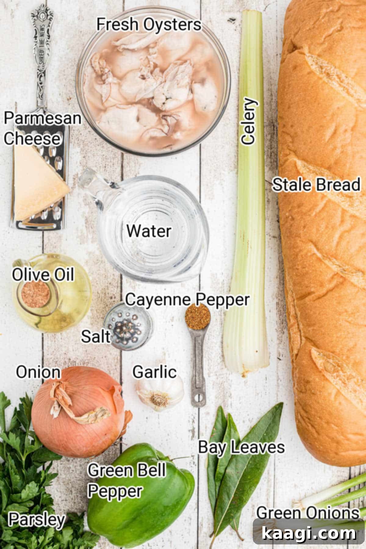 Ingredients for Emeril's oyster dressing laid out on a wooden surface, including fresh oysters, vegetables, and bread cubes.