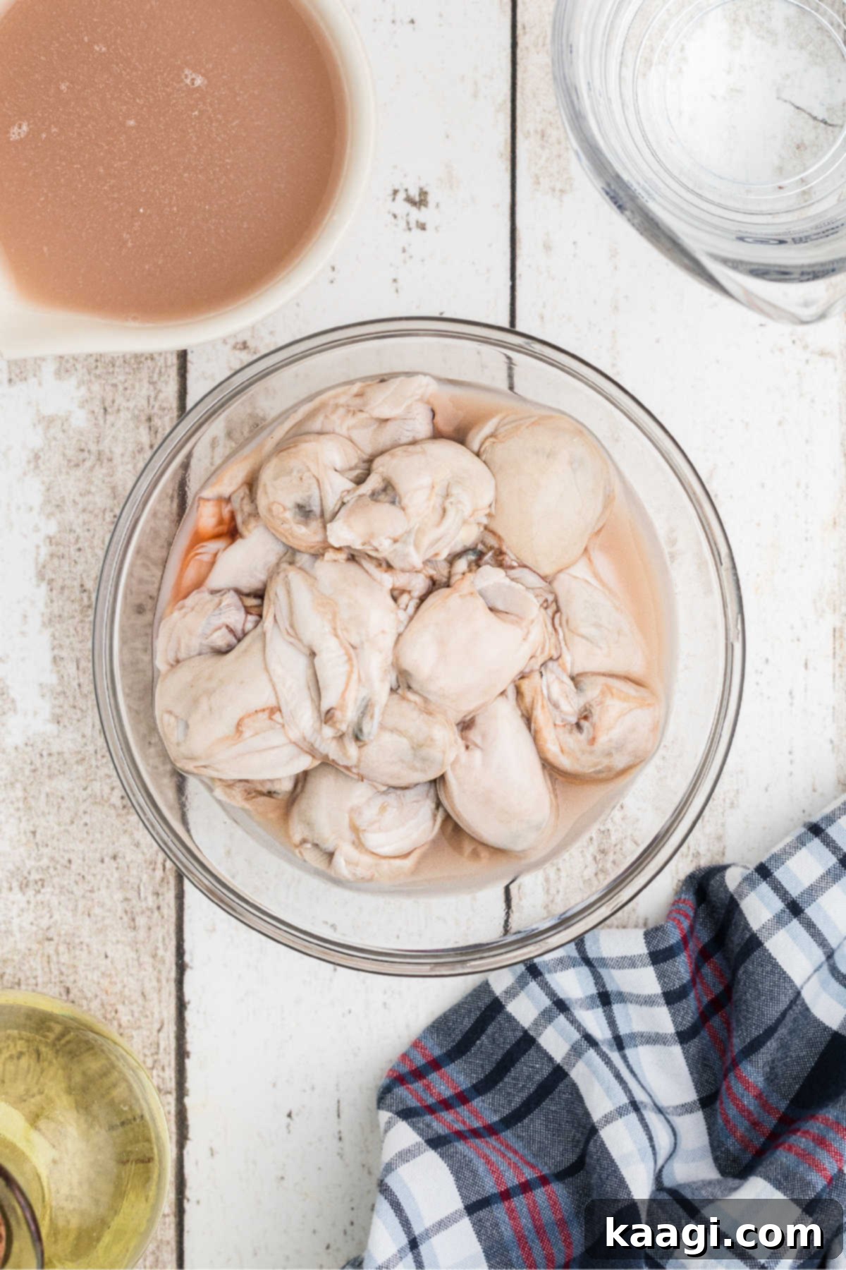 A small bowl brimming with fresh, shucked oysters, glistening with their natural liquor.