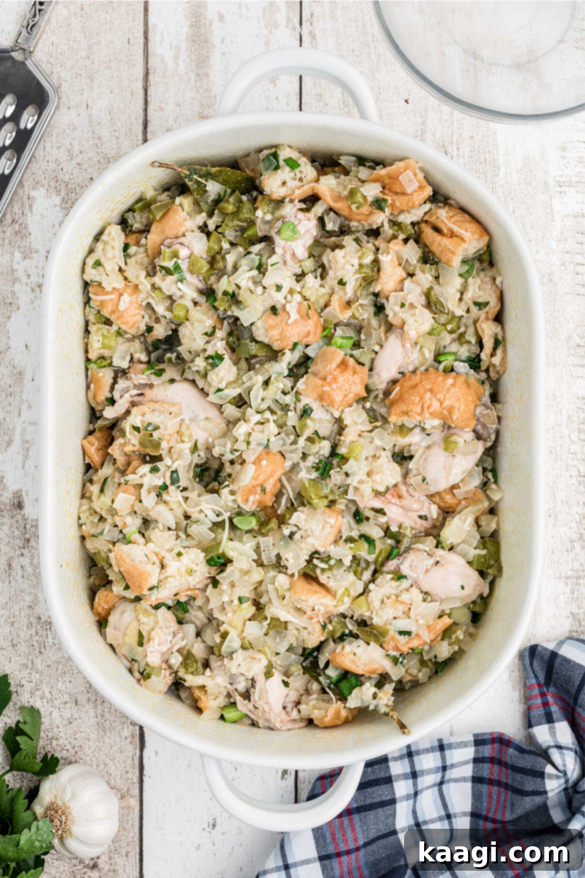 The traditional oyster dressing mixture being transferred into a large, greased casserole dish.
