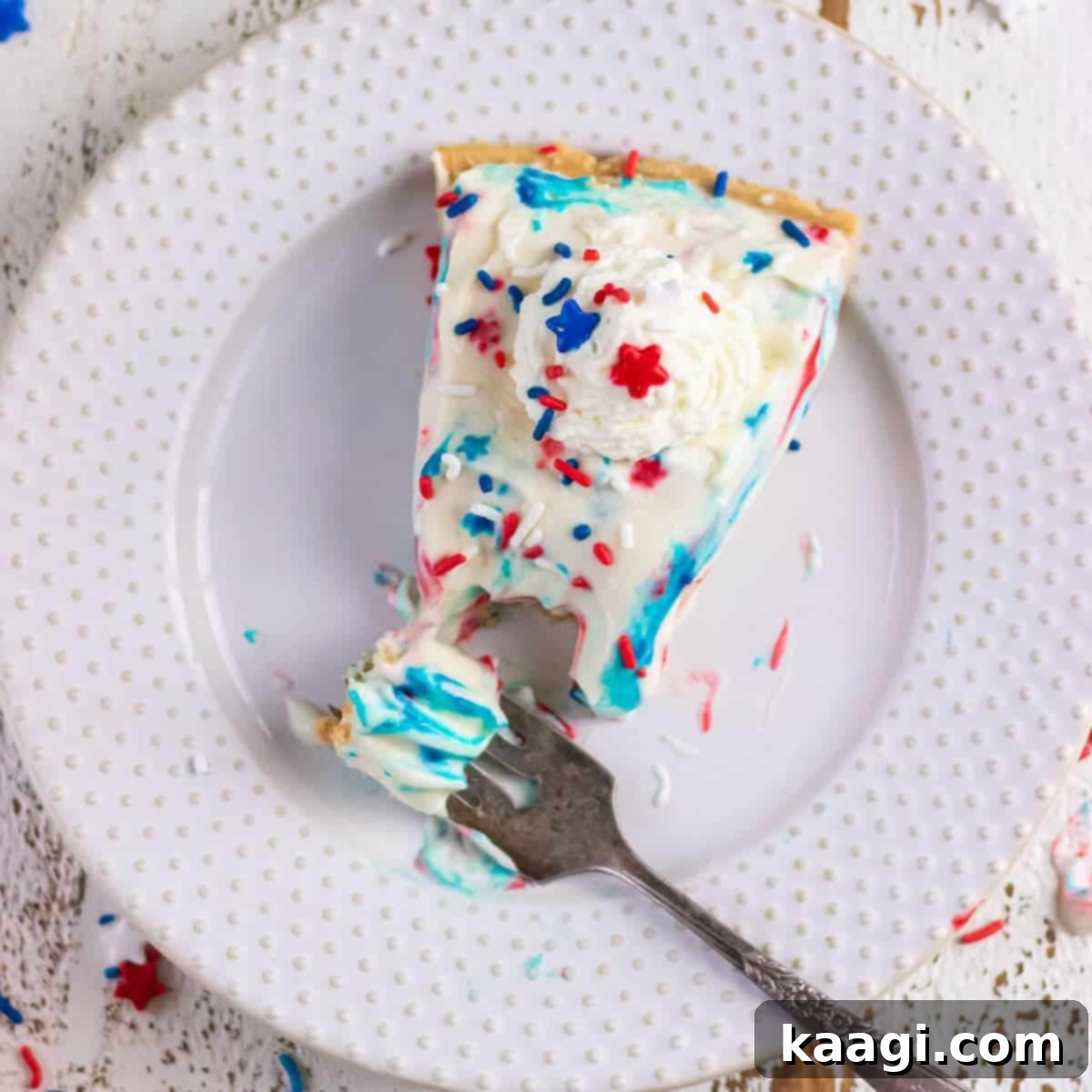 A slice of white chocolate no bake cheesecake pie, garnished with fresh berries and chocolate shavings, showing its smooth texture.
