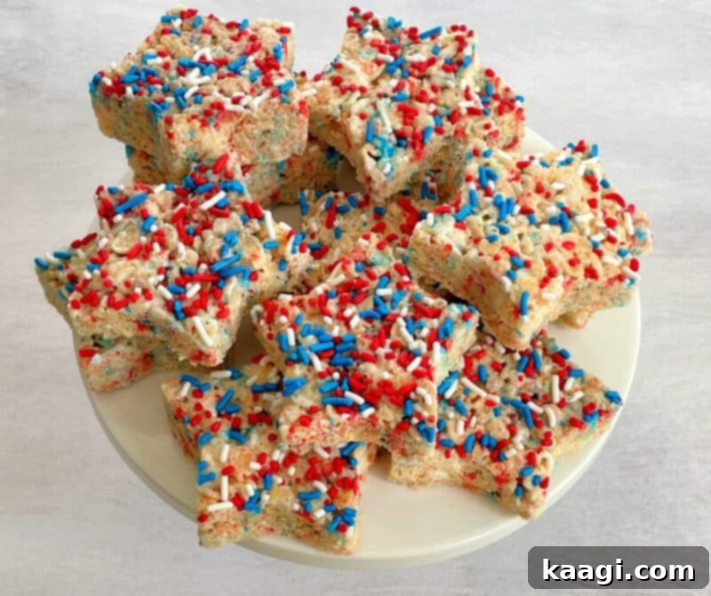 Festive Rice Krispie Treat Stars in red, white, and blue, drizzled with white chocolate and sprinkles.