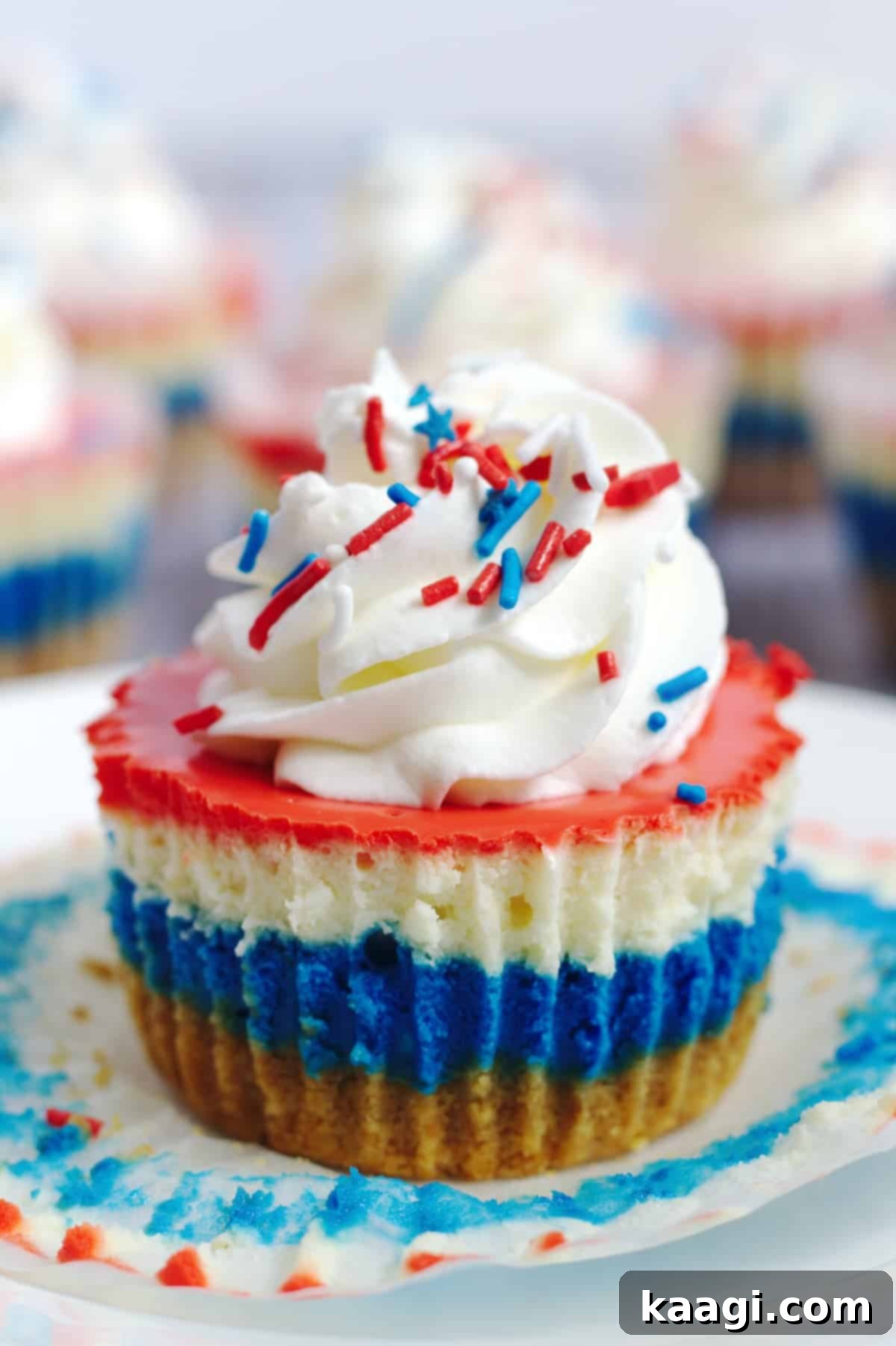 Red, White and Blue Mini Cheesecakes, topped with fresh berries, arranged on a serving tray.