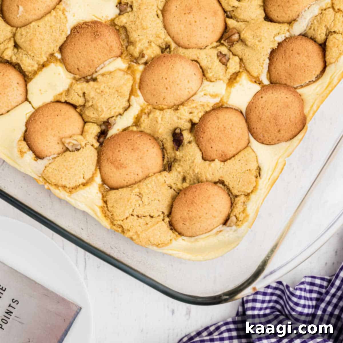 A close up of finished banana pudding brownies with crushed vanilla wafers on top, showing layers of rich brownie and creamy pudding.