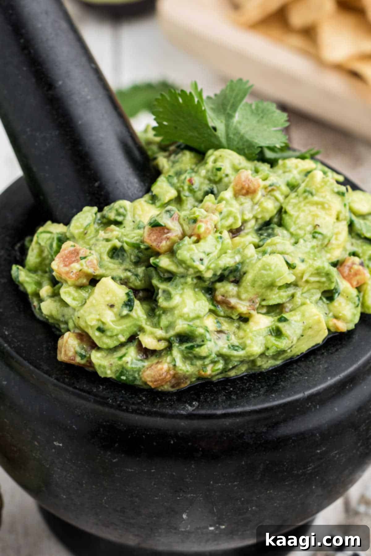 A close-up shot of a molcajete filled with fresh, vibrant green guacamole, showcasing its creamy yet chunky texture.