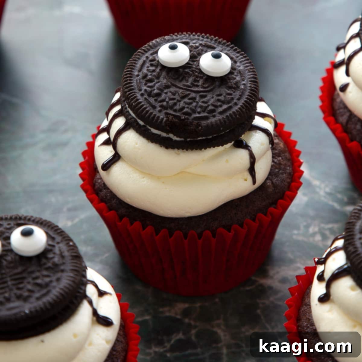 Vegan Halloween Cupcakes decorated with Oreo spiders and colorful frosting.
