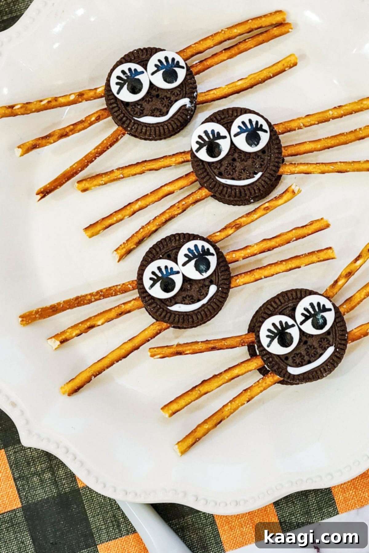 Cute and spooky Oreo Spider Cookies with pretzel legs and candy eyes.