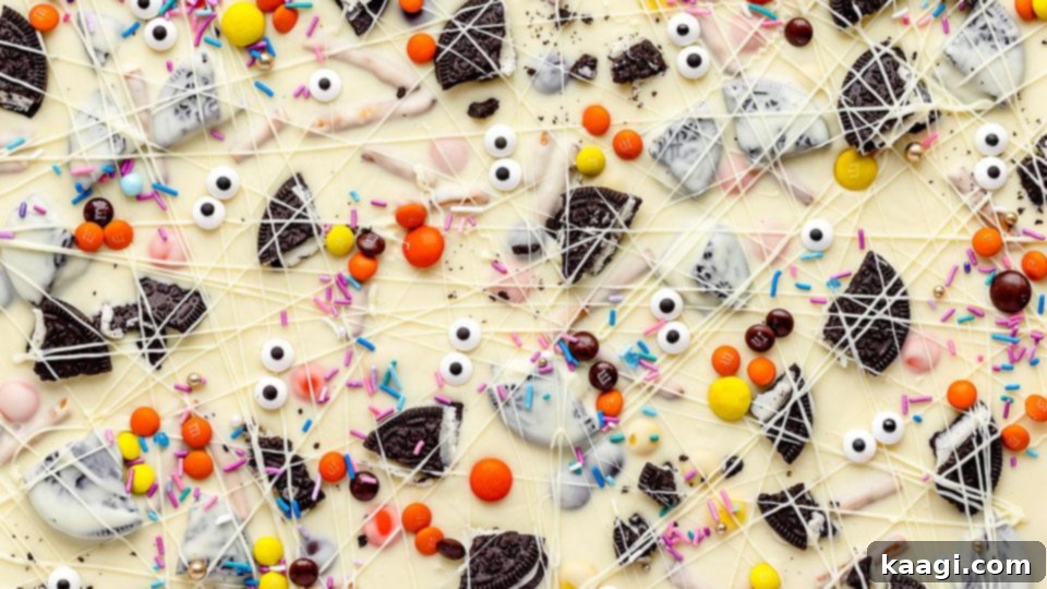 Close-up of spooky Halloween white chocolate candy bark with googly eyes, sprinkles, and crushed Oreos.