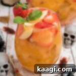 close up of a glass of jungle juice with a skeleton in the background.