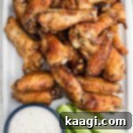 Crispy Air Fryer Ranch Wings 7 A close up shot of some air fried ranch chicken wings with some celery and ranch dip, showcasing their appealing texture.