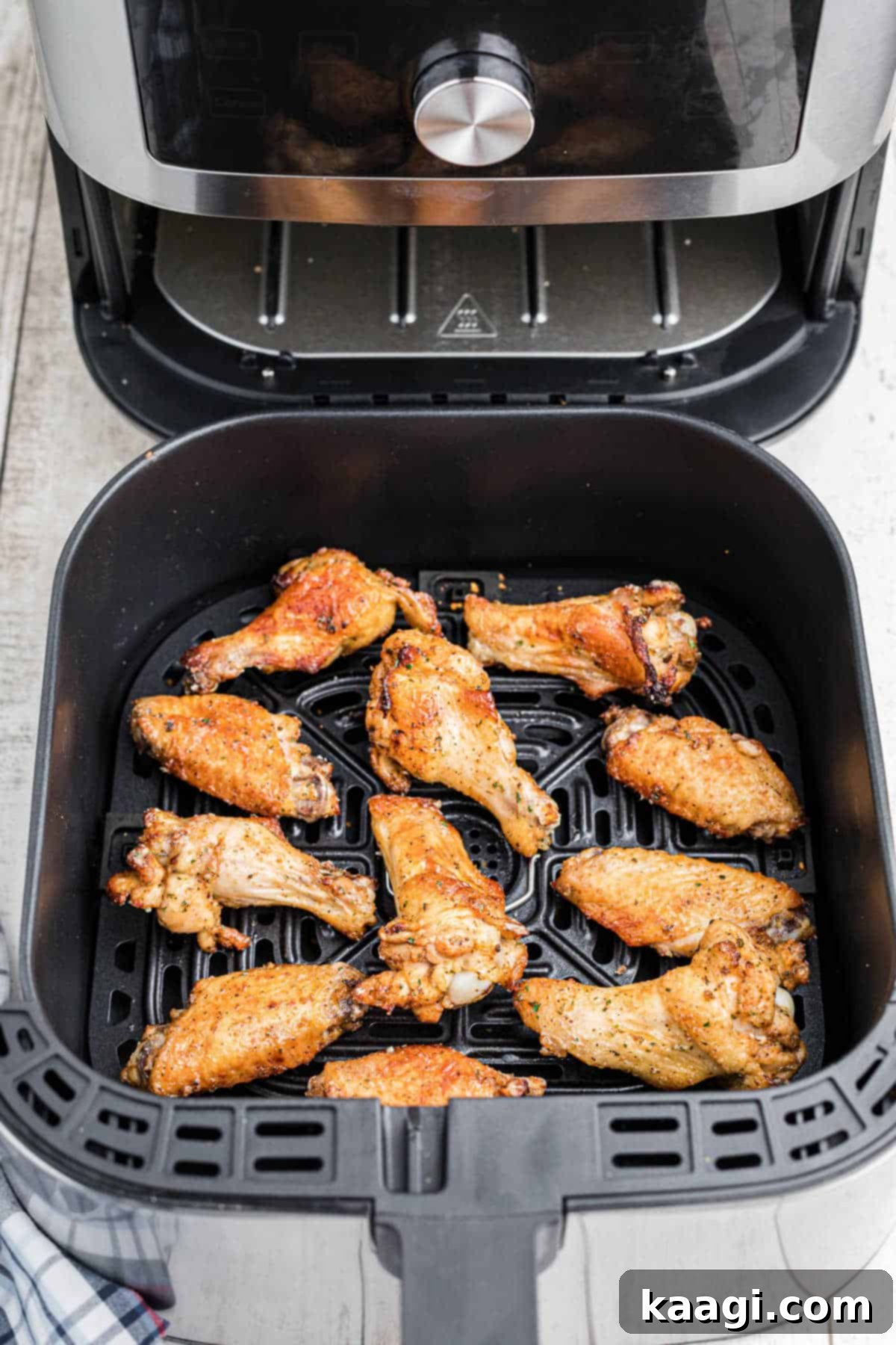 Crispy Air Fryer Ranch Wings 4 A shot of some air fryer ranch chicken wings cooking inside an air fryer basket, showing their golden brown color.