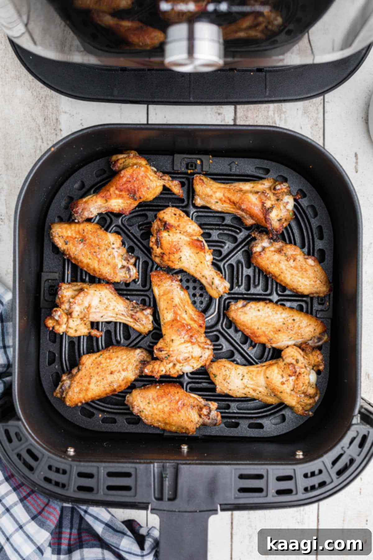 Crispy Air Fryer Ranch Wings 6 An air fryer basket filled with perfectly cooked and seasoned ranch chicken wings, ready to be served.