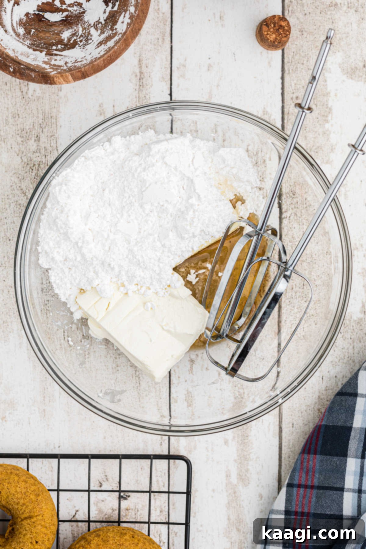 A bowl of ingredients needed to make cream cheese frosting with some beaters.