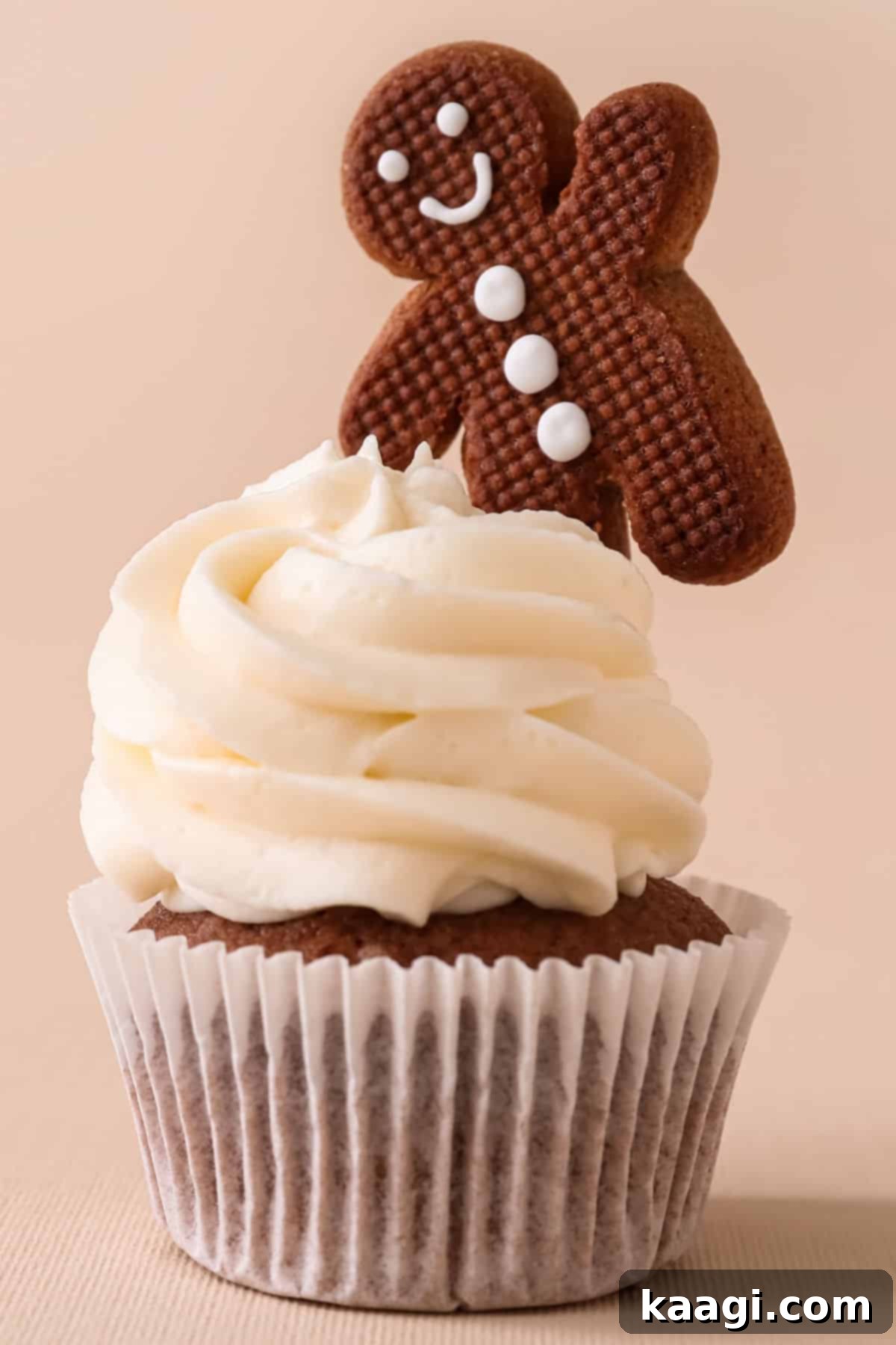 A gingerbread cupcake with a gingerbread man sticking out the top.