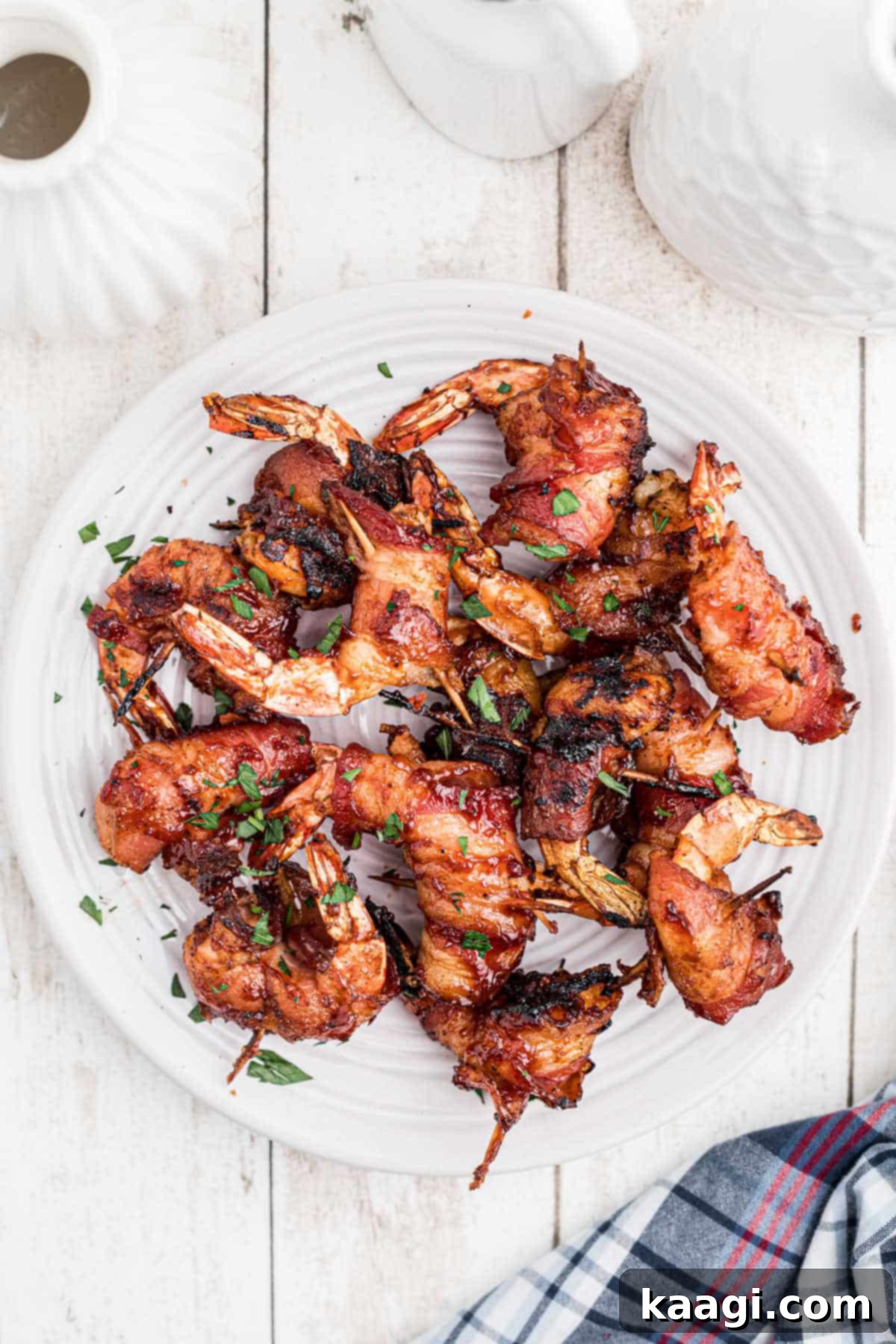 Overhead shot of a platter piled high with smoked bacon wrapped shrimp, ready to serve