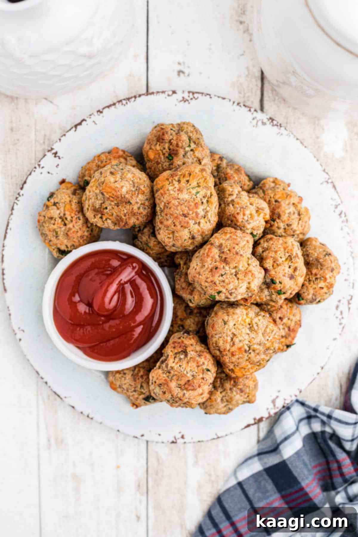 Crispy Air Fryer Sausage Bites 5 Overhead shot of a plate full of air fryer sausage balls and a small bowl of ketchup.