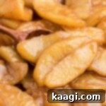 Close up of fried apples with a wooden spoon.