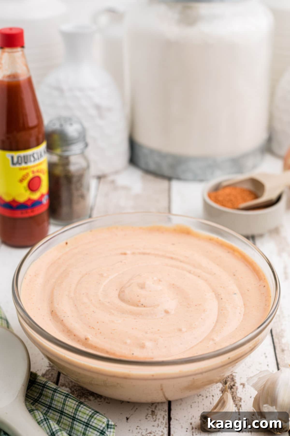 A large bowl of seafood sauce with some ingredients in the background