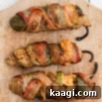 Fiery Smoked Jalapeno Bites 6 Close up of 3 smoked jalapeno poppers, showing their crispy bacon and rich filling.