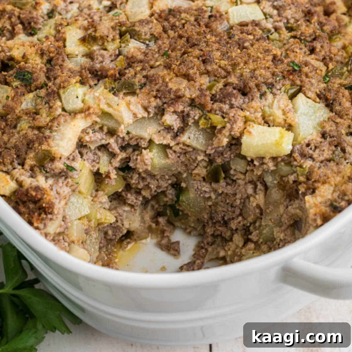 25 Must-Try Cajun Thanksgiving Side Dishes 12 Close up of a dish full of mirliton dressing, with a scoop missing.