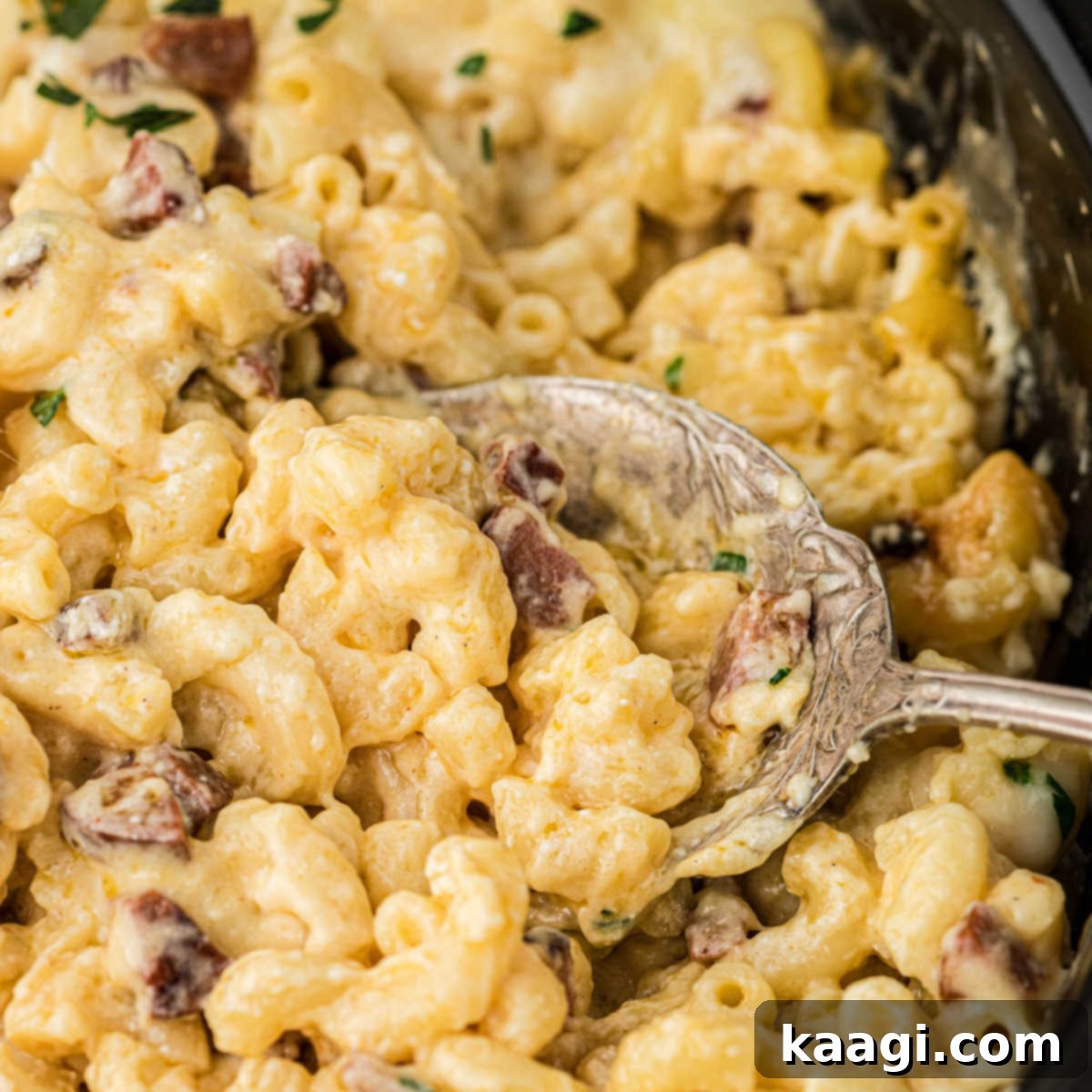 25 Must-Try Cajun Thanksgiving Side Dishes 8 Close up of a spoon digging into a slow cooker cajun mac and cheese dish.