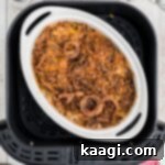 Overhead view of a dish inside the basket of an air fryer with green bean casserole, showcasing the crispy topping.