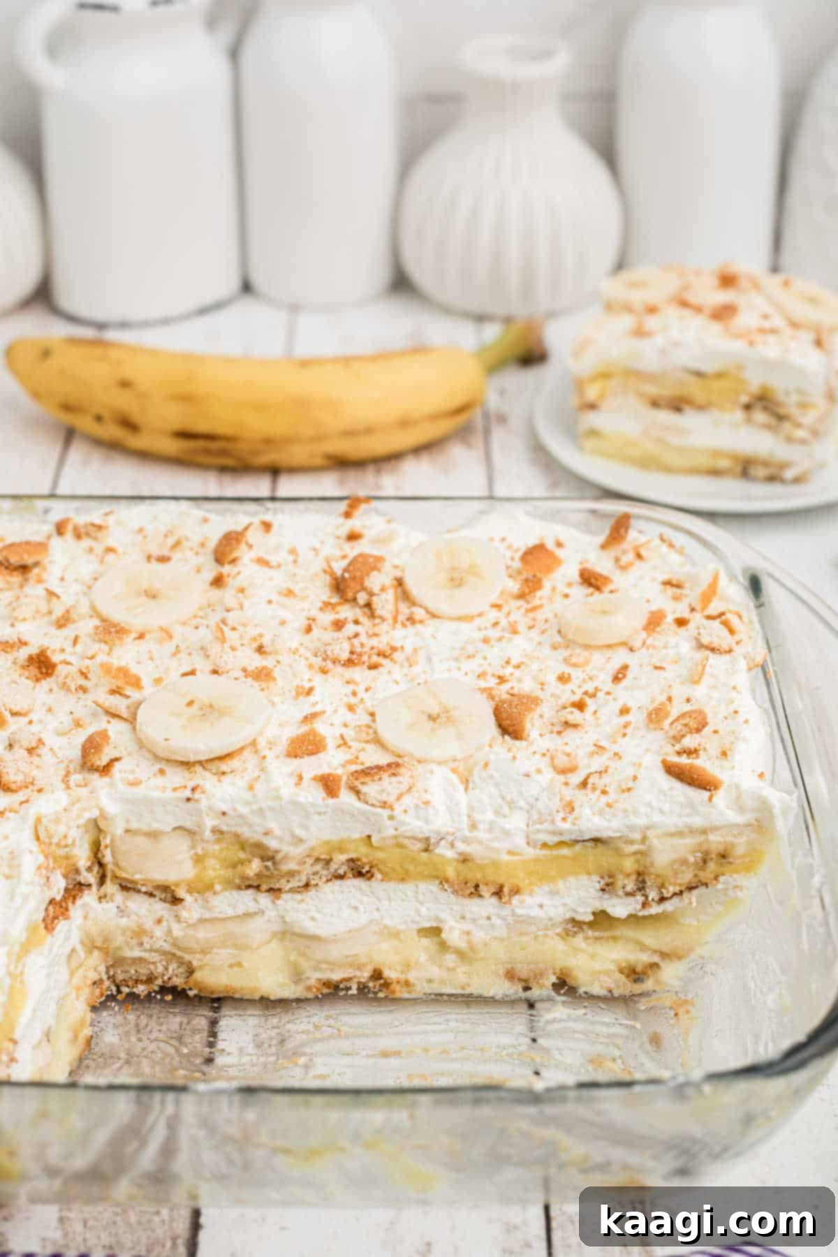 View from the side of a dish with banana pudding in it with a few pieces taken out.