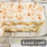 A dish full of no bake banana pudding with a few pieces missing, ready to be served.