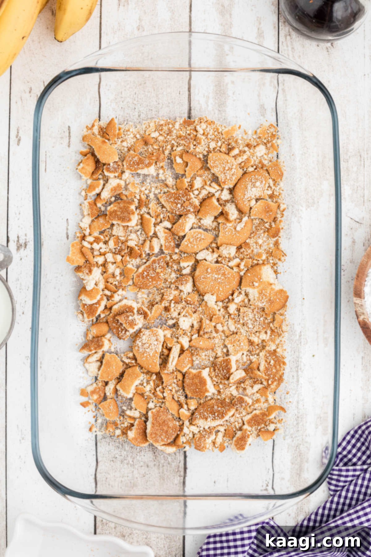 A baking dish with crushed vanilla wafers lining the bottom.