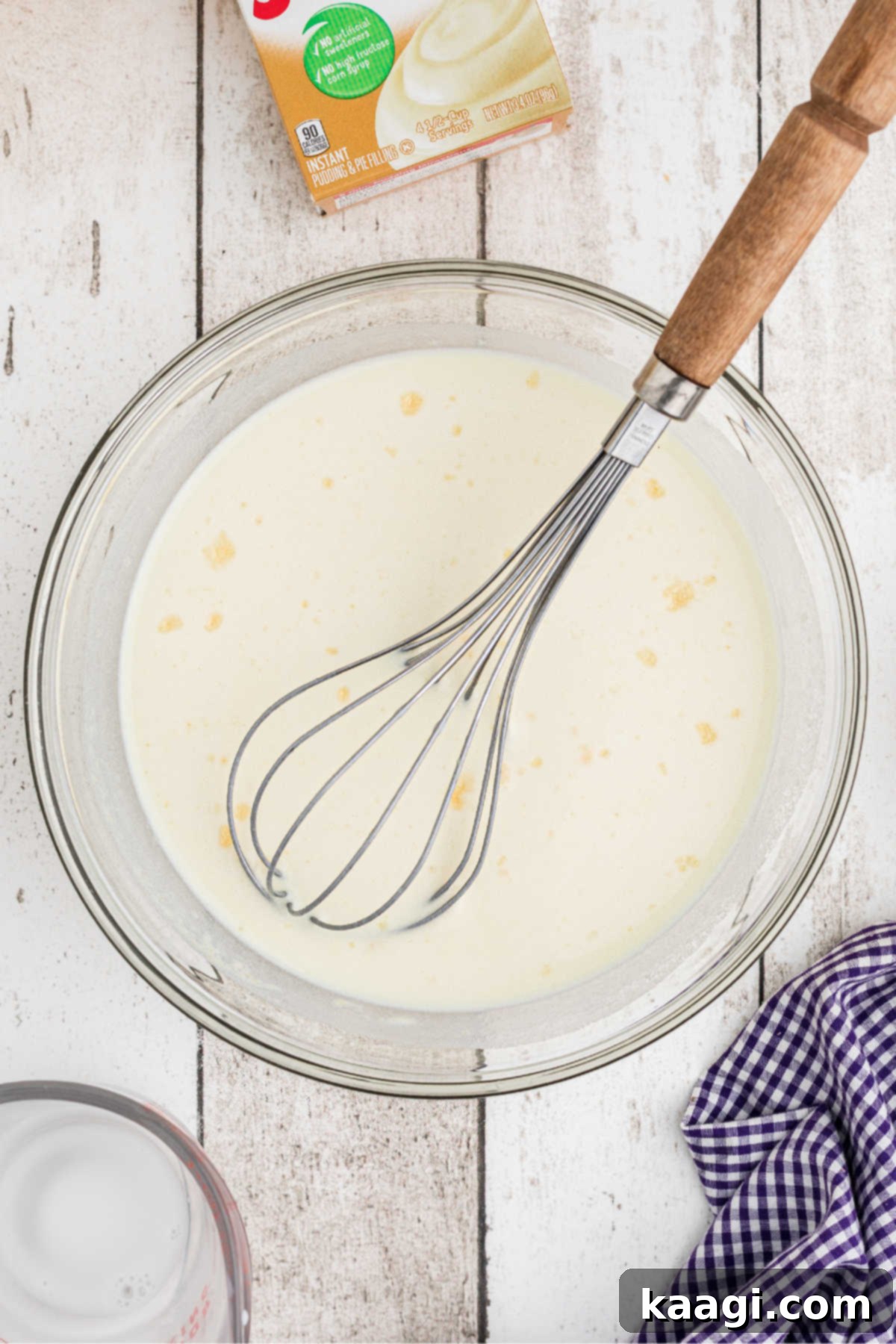 A mixing bowl with pudding being mixed with a whisk.