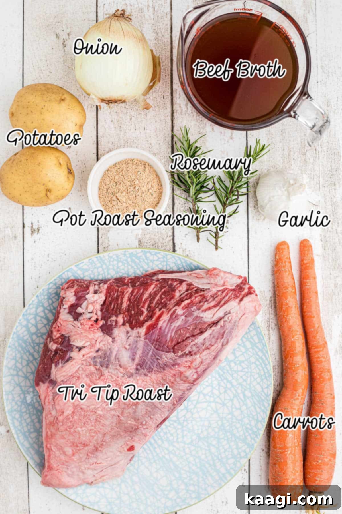 Tender Slow Cooker Tri Tip Roast 3 Collection of fresh ingredients arranged for making a tri tip roast, including onions, garlic, rosemary, potatoes, carrots, and seasoning.