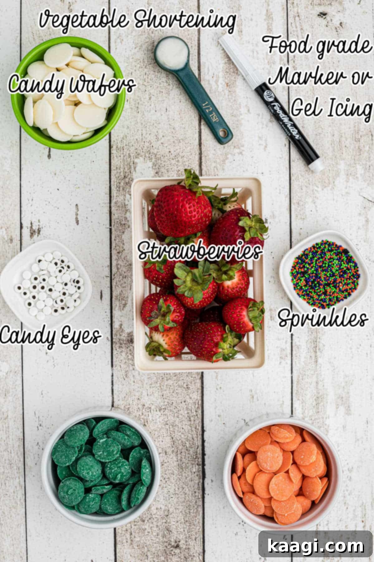 Ingredients needed to make Halloween chocolate covered strawberries, laid out on a white surface.