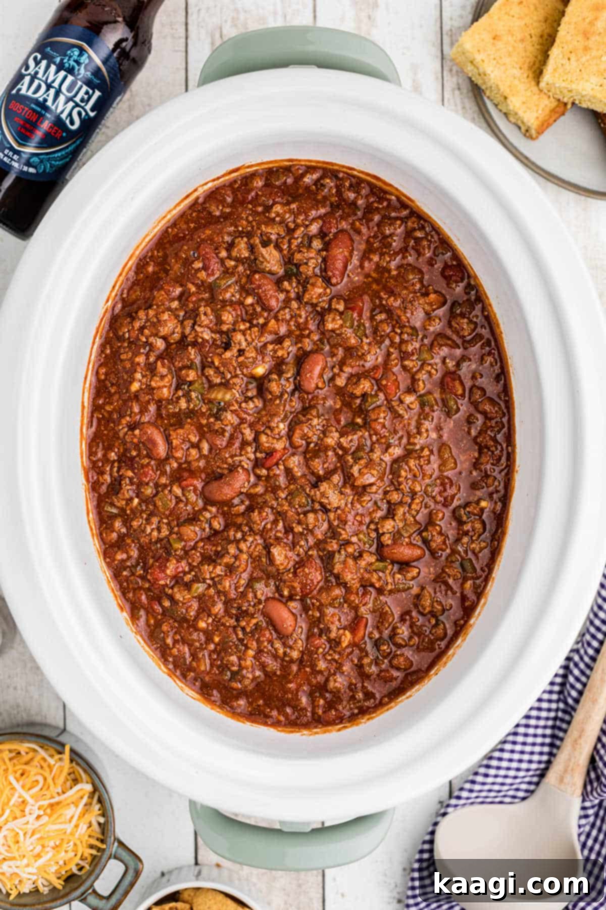 Overhead shot of a crock pot of beer chili, garnished with fresh herbs, ready to be served for game day.