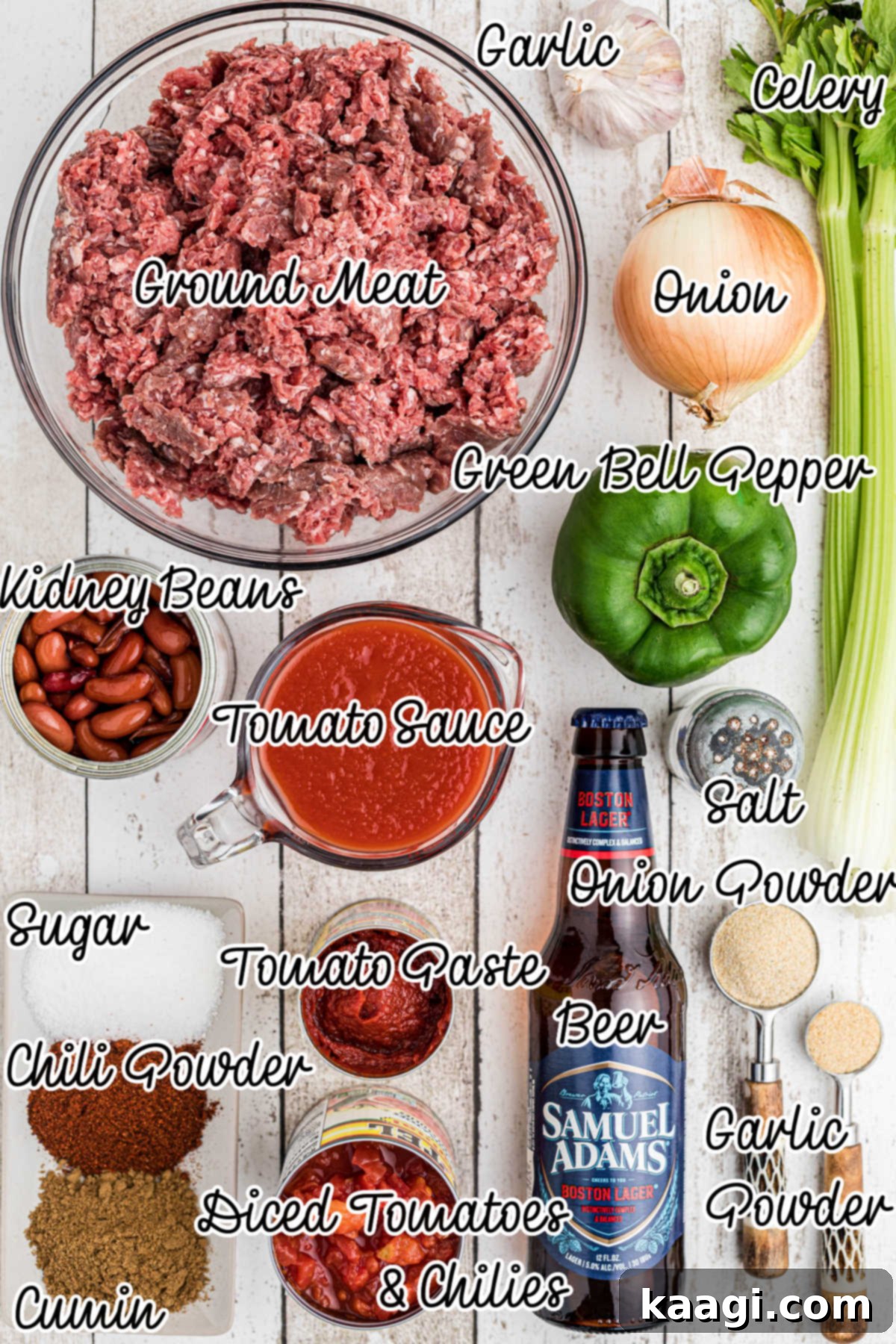 A selection of fresh ingredients laid out, including diced onions, bell peppers, celery, garlic, cans of beans, tomato paste, diced tomatoes, tomato sauce, and spices, alongside a bottle of beer.