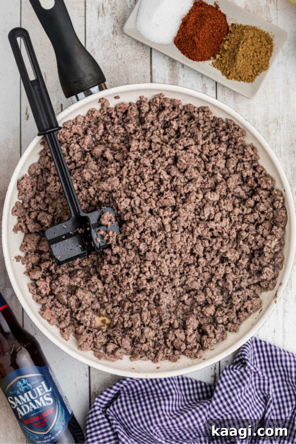 Ground meat browning in a large skillet, ready to be added to the chili.