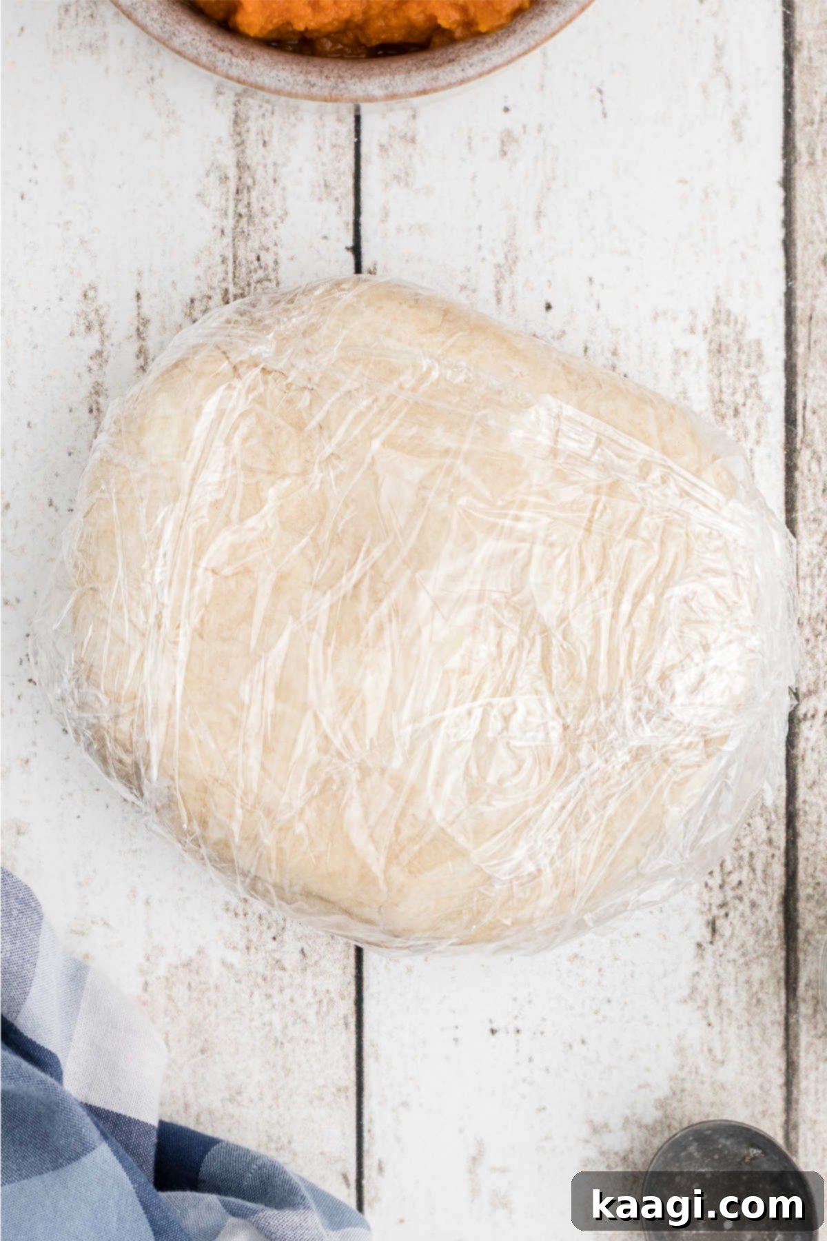 Pie dough wrapped in plastic wrap, to be refrigerated.