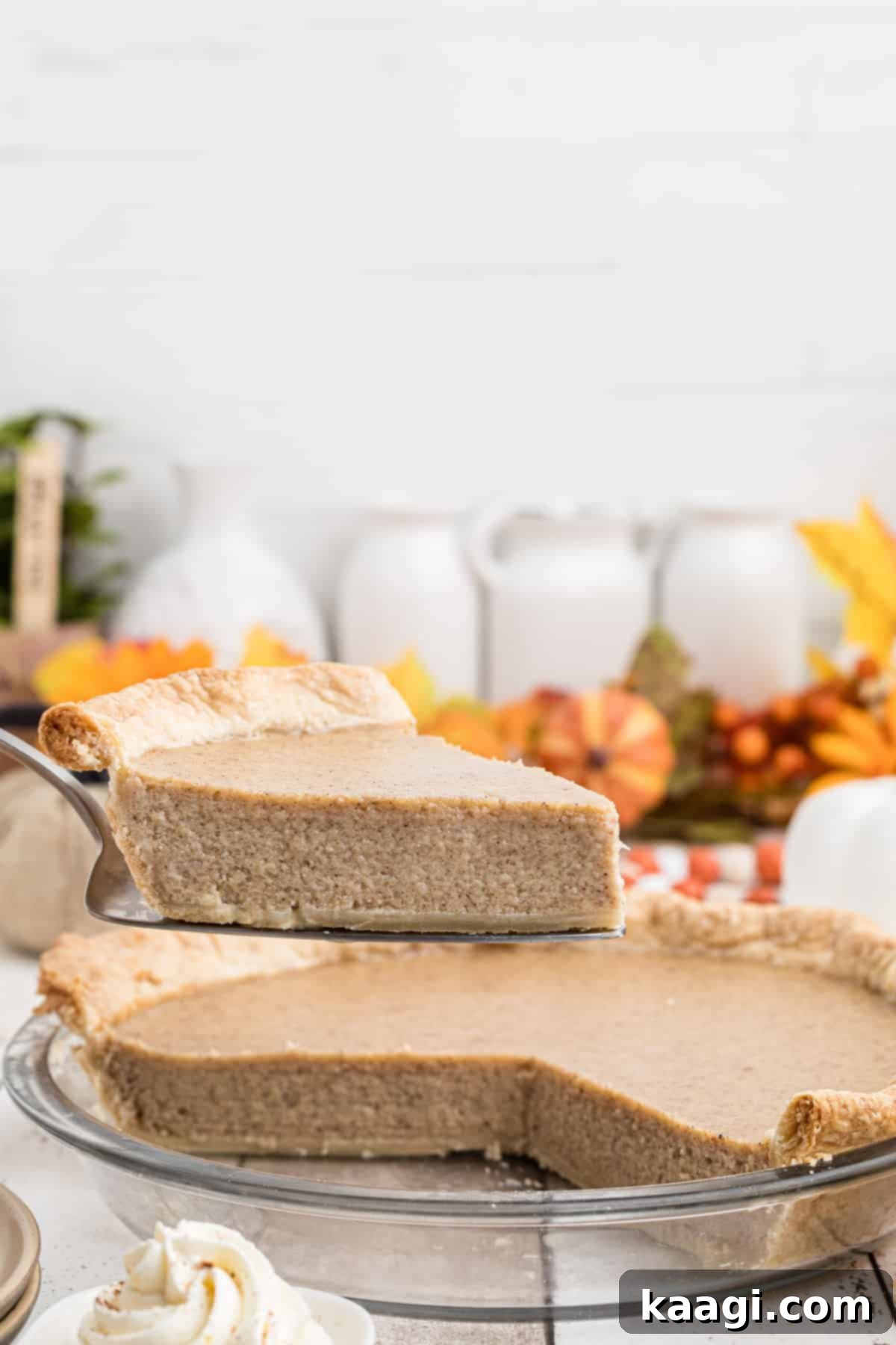 A slice of white pumpkin pie being pulled out of a pie dish.