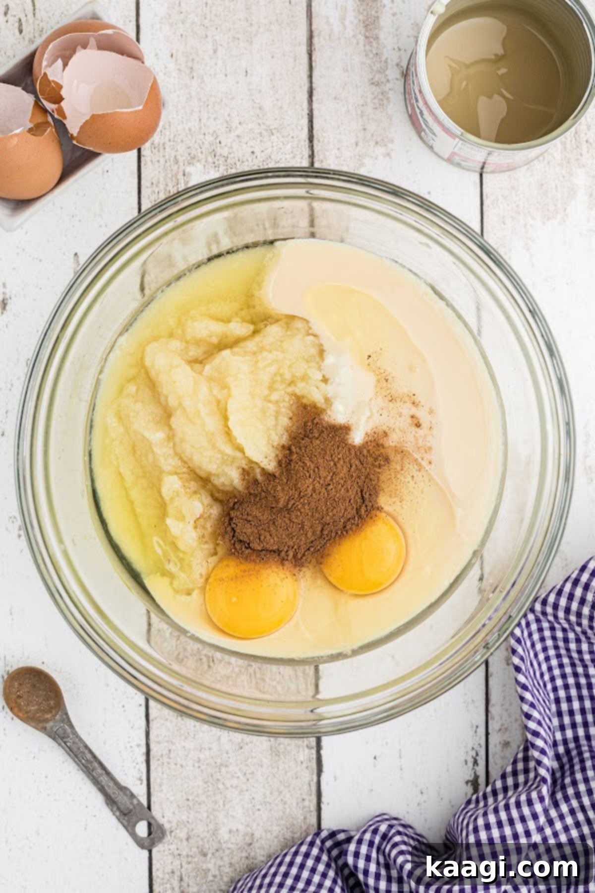 A large mixing bowl with white pumpkin, eggs and other ingredients about to be mixed.