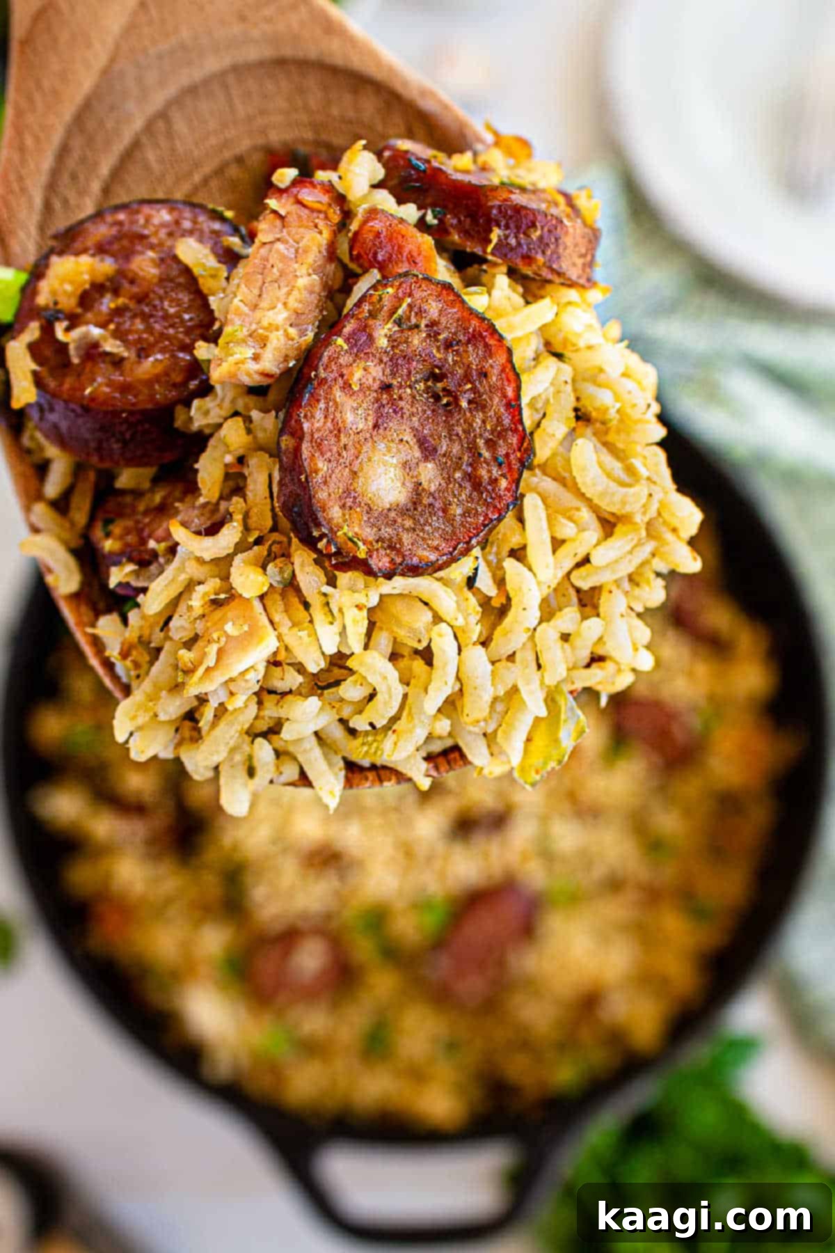 Authentic Louisiana Jambalaya 6 A close-up of a wooden spoon holding a generous serving of Cajun Jambalaya, showcasing the individual rice grains and pieces of meat.