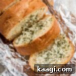 Stuffed garlic bread slightly opened to show inside, revealing a golden interior with melted cheese and herbs.