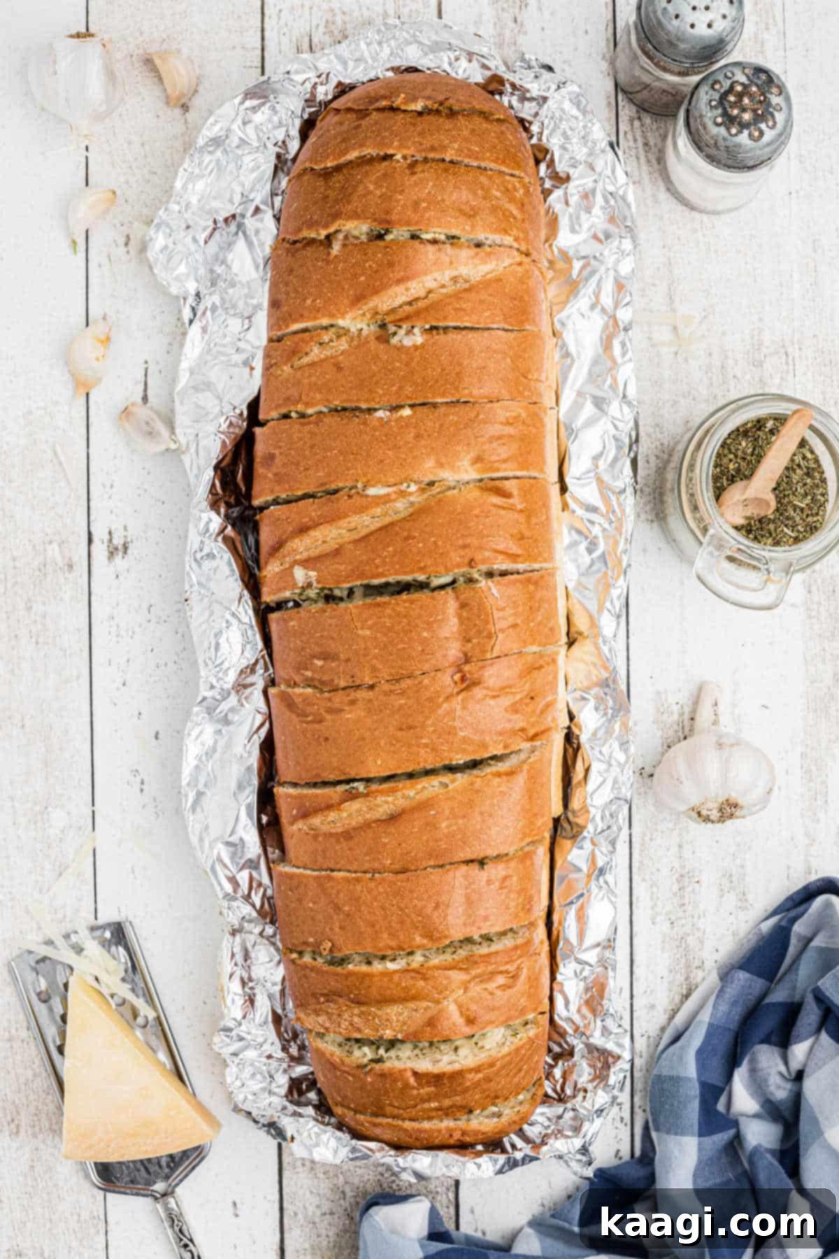 Overhead shot of a full length of stuffed garlic bread, perfectly golden and sliced, ready to be served.