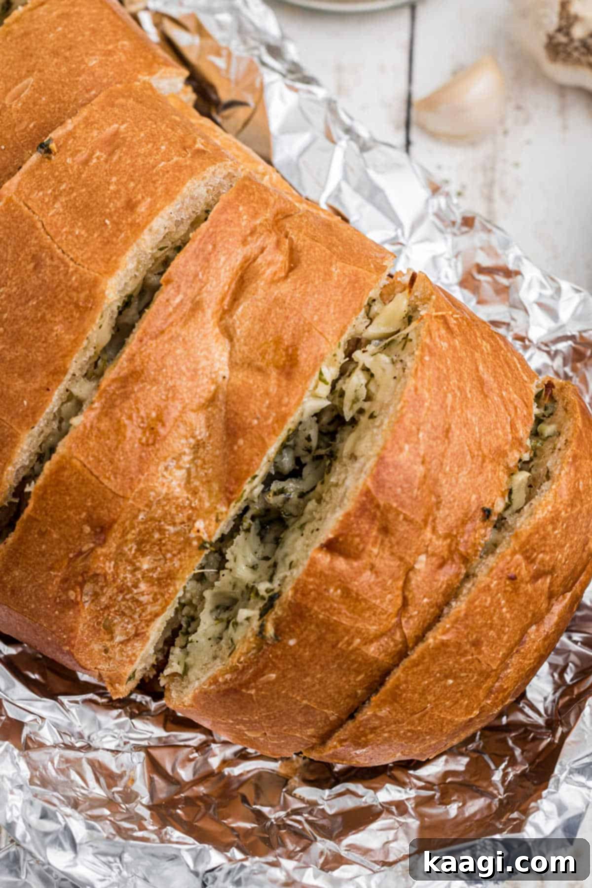 Close up shot of inside a stuffed garlic bread, revealing melted cheese and butter in between slices.