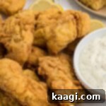 Close-up of golden brown, crispy Cajun fried fish, showing the flaky texture.