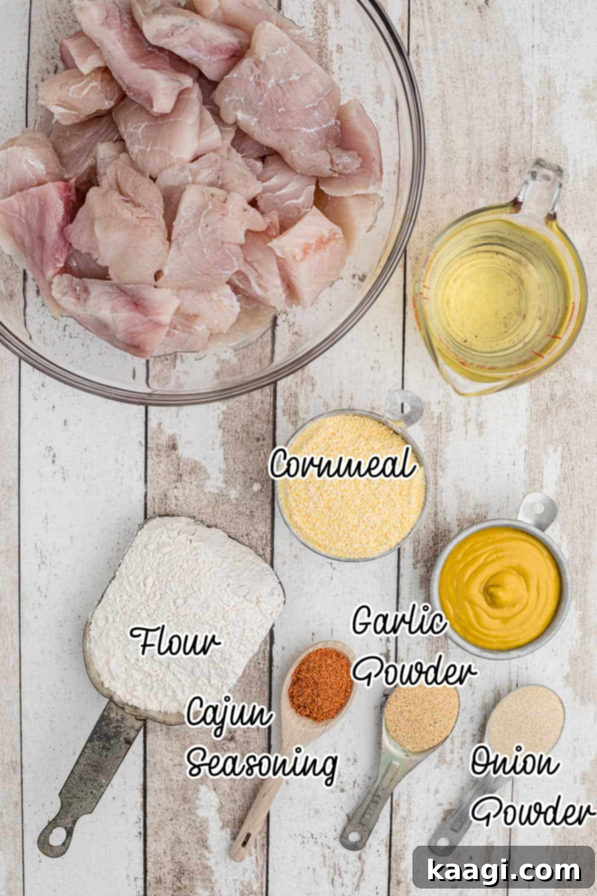 Overhead shot of all ingredients laid out for making a Cajun fish fry, including fish fillets, flour, cornmeal, various spices, and mustard.