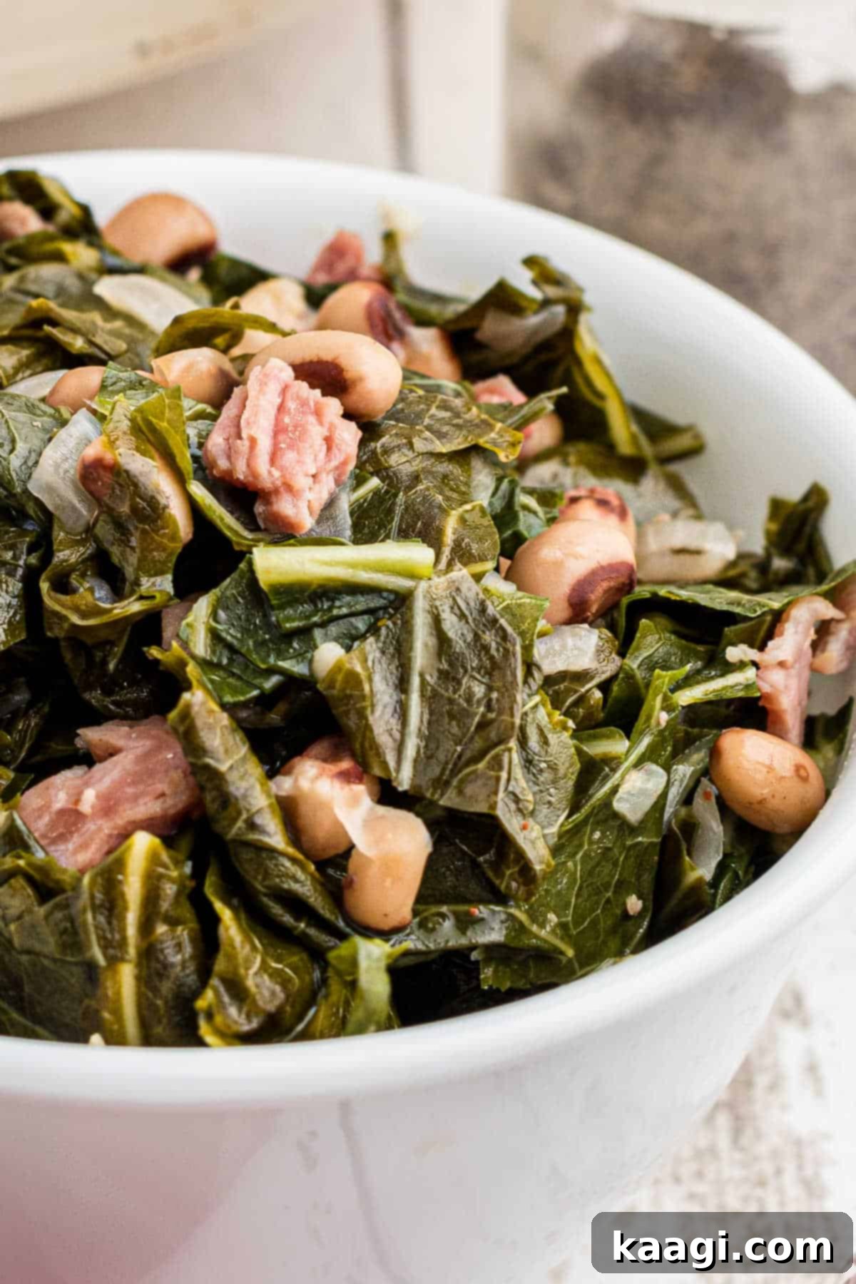 Close up of a bowl of collard greens with black eyed peas, showcasing the rich, savory texture.