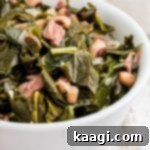 Close up of a bowl of southern black eyed peas and collard greens, garnished with fresh herbs.