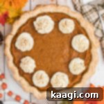 Overhead shot of a sweet potato pie with swirls of cream.