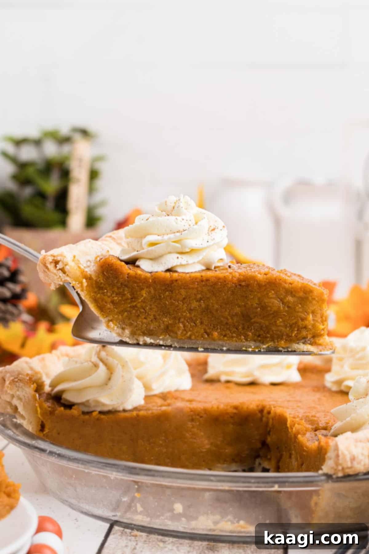 A slice being carefully lifted out of an old fashioned sweet potato pie, showing its rich, creamy texture.